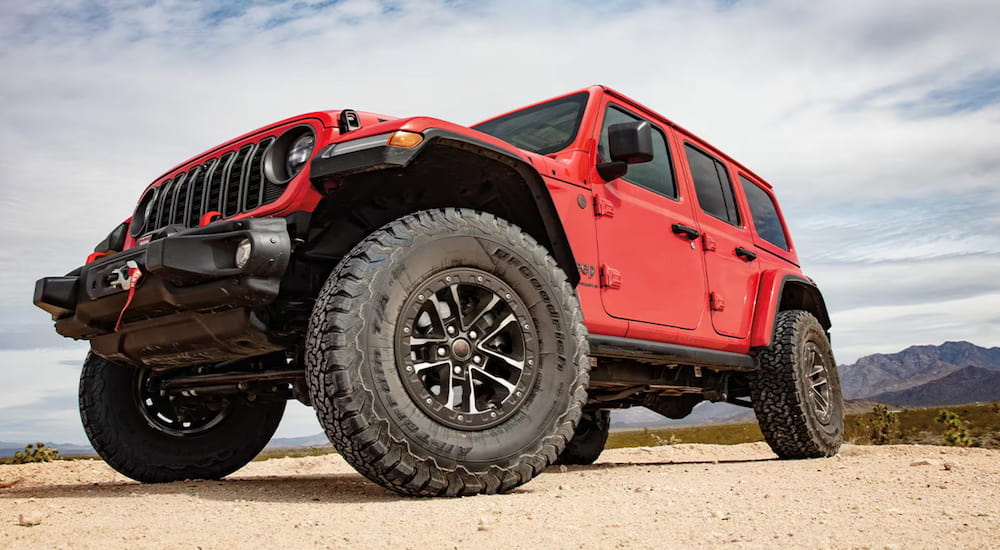 Low angle view of a red 2026 Jeep Wrangler parked off-road.