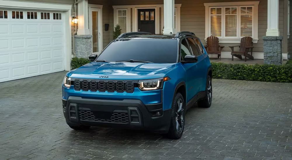 Blue 2026 Jeep Cherokee parked on a grey brick driveway
