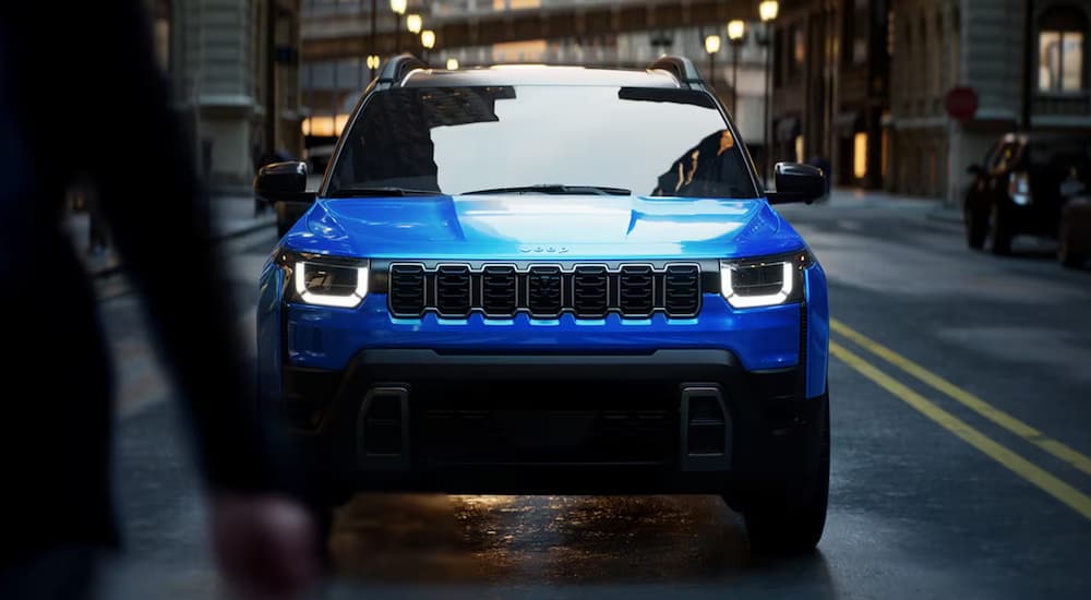Blue 2026 Jeep Cherokee stopped at a crosswalk in a city