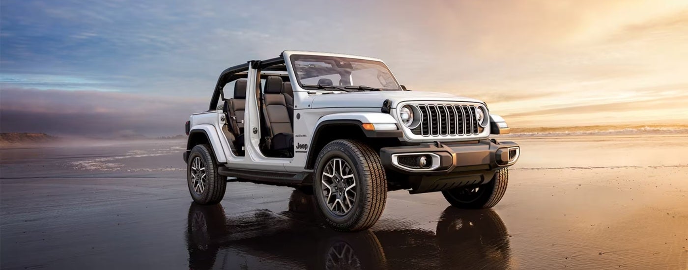 A white 2025 Jeep Wrangler from the front at an angle after leaving a Jeep dealer.