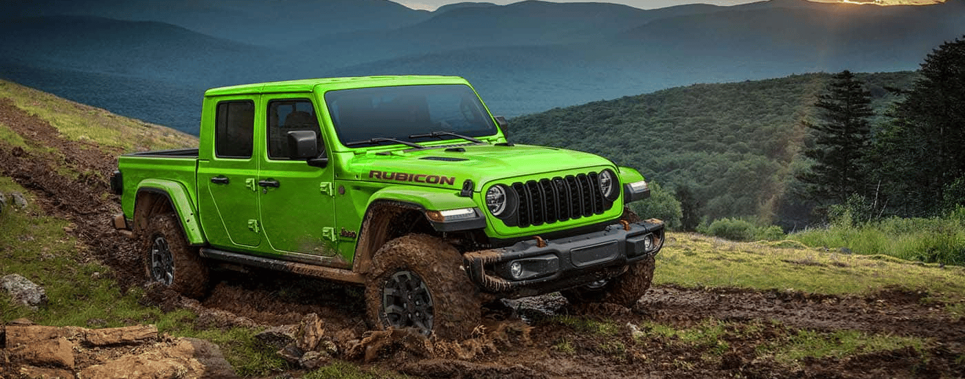 Green 2026 Jeep Gladiator Rubicon driving through mud