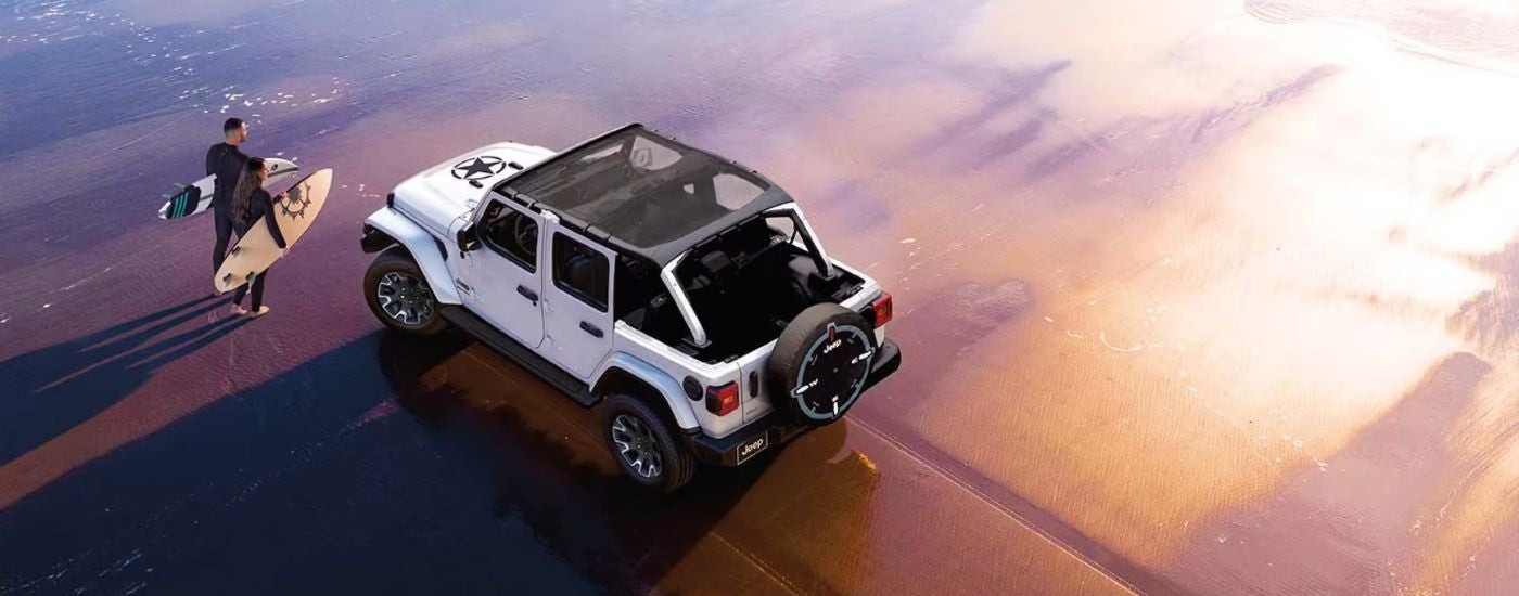 Aerial view of a white 2026 Jeep Wrangler on the beach.