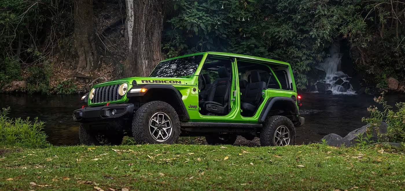 A green 2026 Jeep Wrangler Rubicon parked offroad.