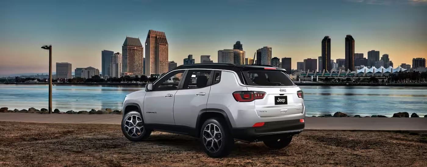A white 2025 Jeep Compass parked near water.